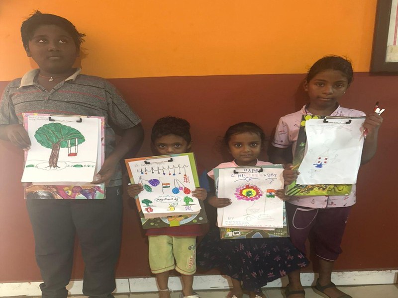 Four children showing the pictures they drew